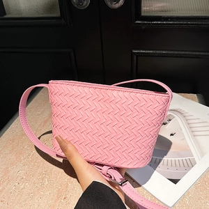 Close-up of pink woven crossbody bag showing textured faux leather and silver metal buckle