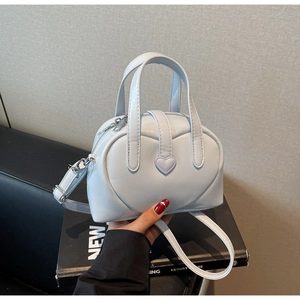 Detailed view of pale blue Boston bag featuring heart quilting and silver zippers