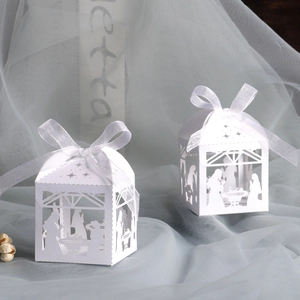 Laser-cut white gift box with nativity scene design and white silk ribbon bow