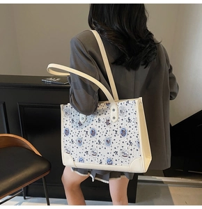 Vue portée d'un sac cabas blanc avec motifs d'oursons bleus et de nœuds