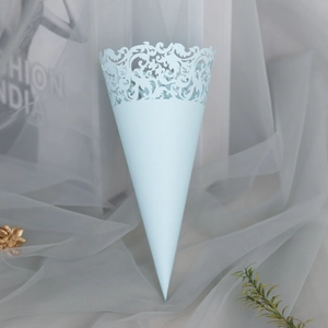 Detail of mint green laser-cut wedding petal cone with intricate lace scroll pattern