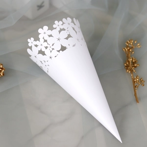 Macro detail of white laser-cut hollow flower wedding cone for petals on blue tulle