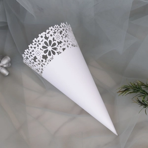 Detailed close-up of white laser-cut paper wedding cones with elegant floral patterns