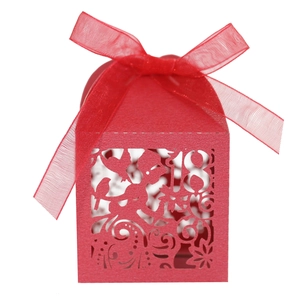 Detail of red laser-cut candy box with fairy pattern, number 18 and a satin ribbon bow