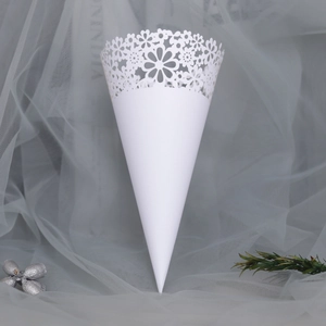 Macro view of white laser-cut hollow lace pattern on wedding confetti paper cone