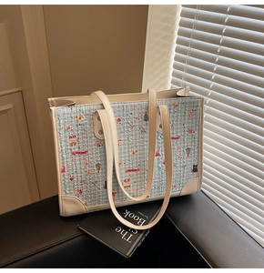 Détail macro du sac cabas en tweed bleu clair avec des motifs de dessins animés colorés