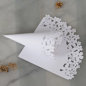 Detail of white laser-cut hollow lace paper cones with flower and star patterns