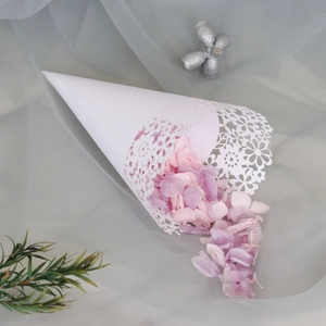 Close-up of white laser-cut floral paper cone filled with pink and purple petals