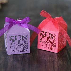 Close-up of laser-cut number 18 and floral patterns on purple and coral gift boxes