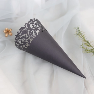 Detail view of a black laser-cut hollow paper cone for weddings on elegant white tulle