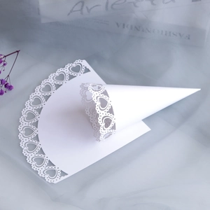Detailed laser-cut heart pattern on white paper wedding confetti cones for celebration