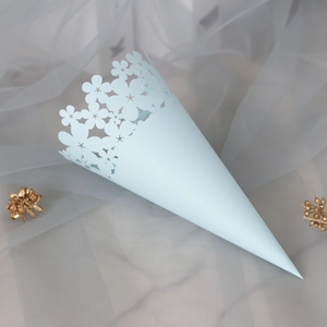 Detail of light blue laser-cut flower pattern on paper cone for wedding confetti