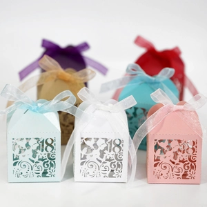 Detail of laser-cut 18th birthday candy boxes with elegant organza ribbons and patterns