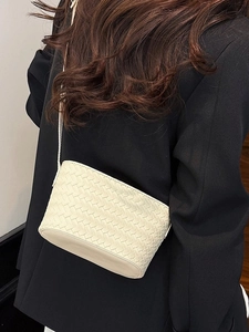 Chic white woven leather crossbody bag styled with a professional black blazer