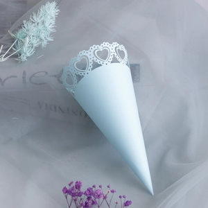 Detail of light blue cone paper confetti holder with laser-cut heart lace edge for weddings