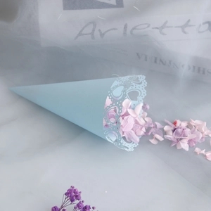 Detail of light blue wedding petal cone with hollow heart lace edges and dried flowers