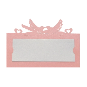 Detail of pink laser-cut wedding table card featuring birds and heart designs