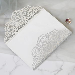 Détail de l'invitation rose découpée au laser avec paillettes argentées sur marbre