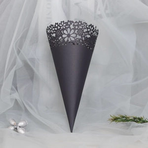 Close-up of elegant black cone with laser-cut floral edge on white mesh background