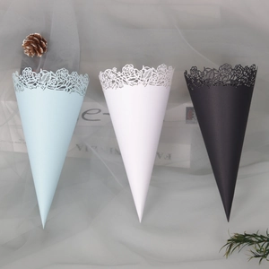 Hollow laser-cut paper confetti cones in blue, white, and black for wedding celebrations