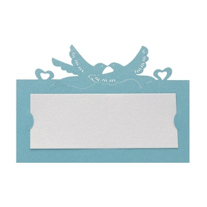 Macro detail of laser-cut heart and dove patterns on sky blue pearlescent wedding place cards