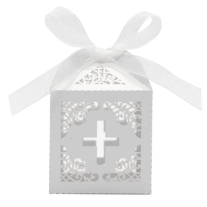 Detail of laser-cut cross pattern on white wedding favor box with ribbon bow