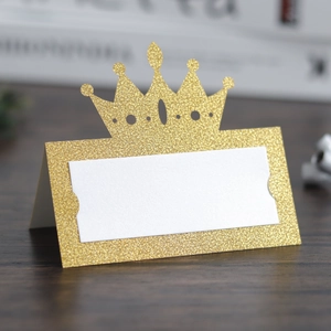 Detail of glitter gold crown place card with elegant hollow design for wedding table