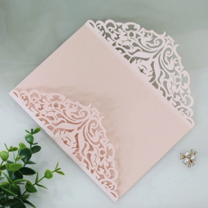 Λεπτομέρεια ροζ θήκης πρόσκλησης laser-cut με περίπλοκα λουλουδάτα σχέδια από μαργαριταρένιο χαρτί
