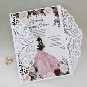 Detail of laser-cut ivory wedding invitation with floral insert and elegant pearl accent