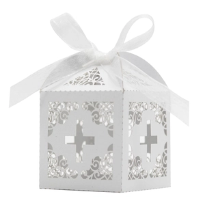 Detail of white laser-cut wedding favor box with cross pattern and satin ribbon bow