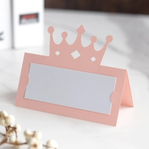 Détail du marque-place rose en forme de couronne avec motif ajouré découpé au laser