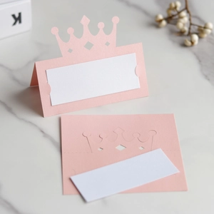 Détail macro du marque-place couronne rose découpé au laser avec insert blanc sur marbre