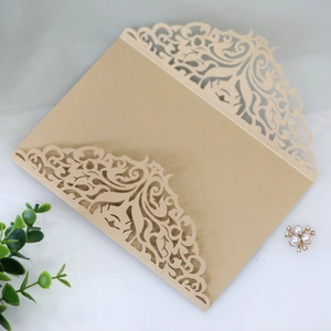 Κοντινό πλάνο χρυσής θήκης πρόσκλησης laser-cut με μπαρόκ λουλουδάτα σχέδια