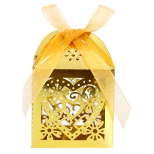 Detail view of golden heart-shaped laser cut candy box with elegant yellow organza ribbon