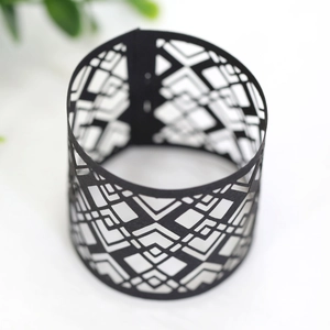 Macro shot of black laser-cut napkin ring featuring intricate geometric hollow patterns