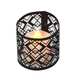 Detail of black geometric hollow candle holder with warm yellow LED light effect