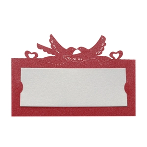 Detail of red hollow laser-cut wedding place card with love birds and white insert card