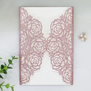 Détail du faire-part rose à paillettes découpé au laser avec motif floral de rose