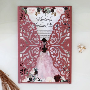 Detail of laser-cut burgundy invitation featuring delicate butterfly and floral patterns