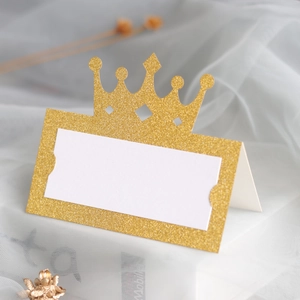Macro shot of gold glitter crown name place card with elegant laser-cut hollow design