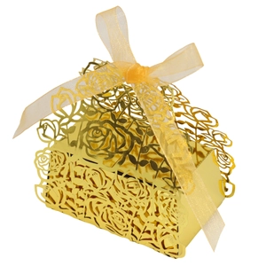 Detail of laser-cut rose patterns on golden wedding candy gift box with ribbon