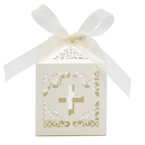 Macro view of white laser-cut cross gift box with intricate scroll patterns and ribbon