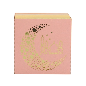 Close-up of pink gift box with gold foil moon and mosque pattern for Eid
