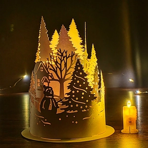 Detailed laser-cut paper lampshade featuring a warm forest winter scene with snowmen