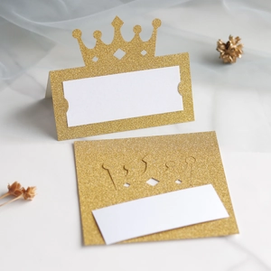 Detail of glitter gold hollow crown place cards with white blank space for names