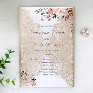 Close-up of glitter gold laser-cut rose invitation with elegant floral inner page