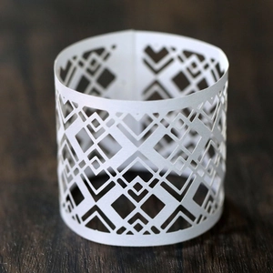 Macro view of white geometric lattice cutout lampshade for LED tea light candles
