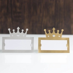 Détail de porte-cartes de table dorés et argentés avec motif de couronne découpé au laser