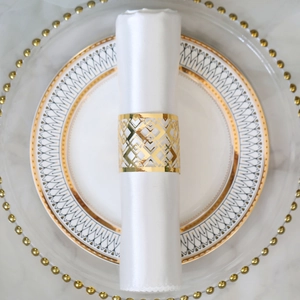 Macro shot of gold geometric laser-cut napkin ring on a white satin cloth