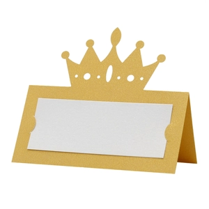 Close-up of golden crown place card with hollow cutout design and blank white insert